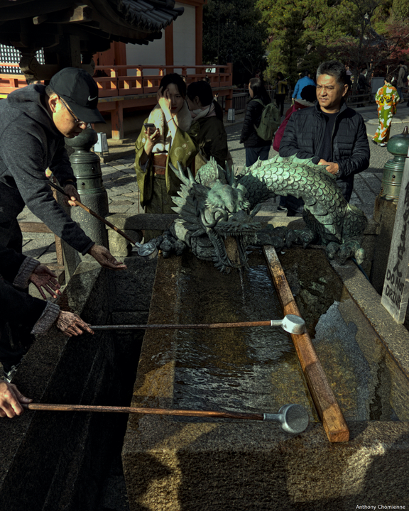 Un Chōzubachi avec un dragon et des personnes l'utilisant pour se purifier avant d'entrer dans un temple shinto