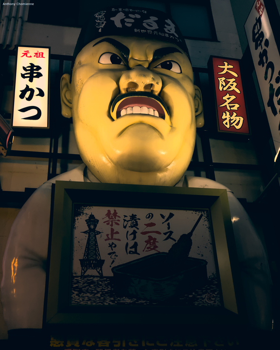 Une énorme enseigne d'un restaurant représentant un cuisinier japonnais qui n'a pas l'air très content