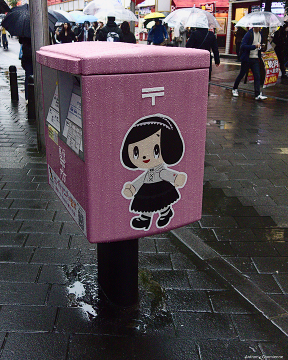 Une boîtes aux lettre de la poste japonnaise rose, avec un sticker un peu cartoon